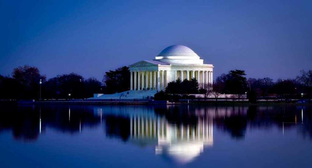 Stunning view of the Jefferson Memorial reflecting in water during twilight in Washington DC.